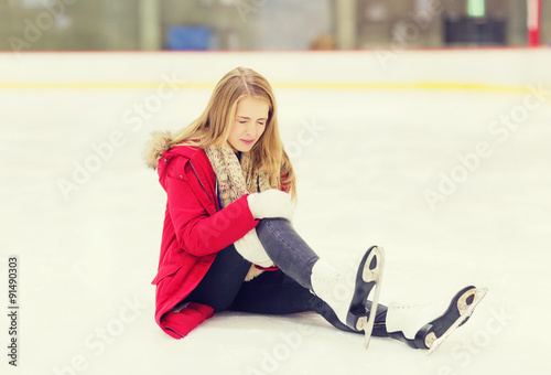 young woman fell down on skating rink