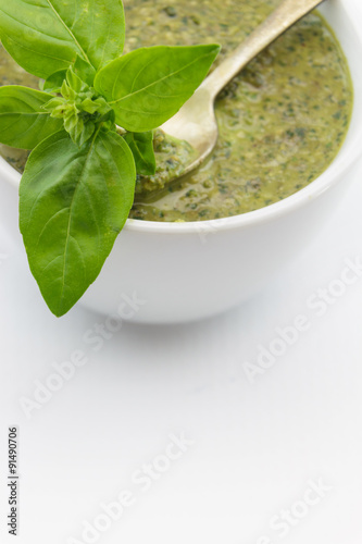 Pesto sauce and basil leaves, isolated on white background