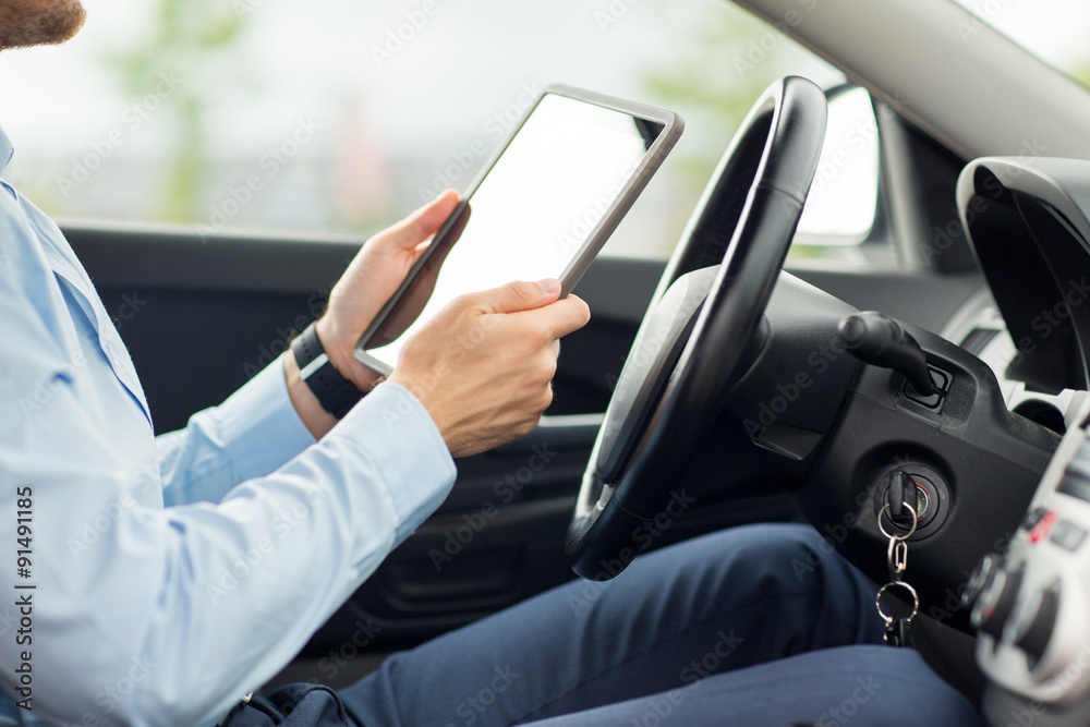 close up of young man with tablet pc driving car