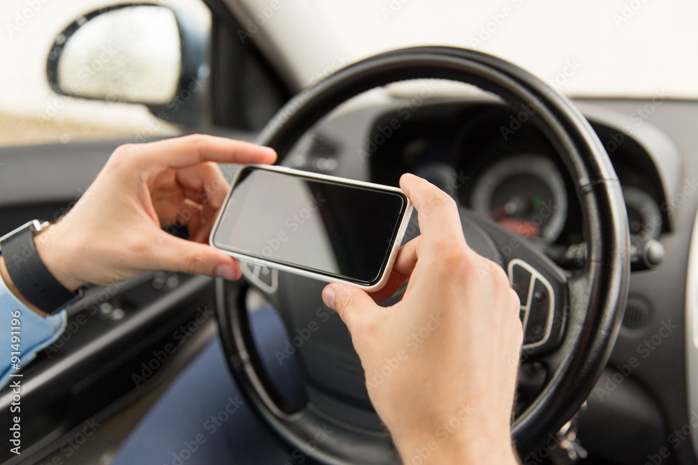 close up of man hand with smartphone driving car