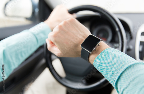 close up of man with wristwatch driving car