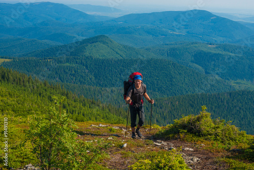 Hiker with trekking poles rises to the top.