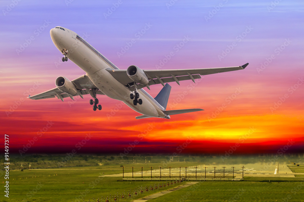 Fototapeta premium Commercial airplane take off at beautiful sunset