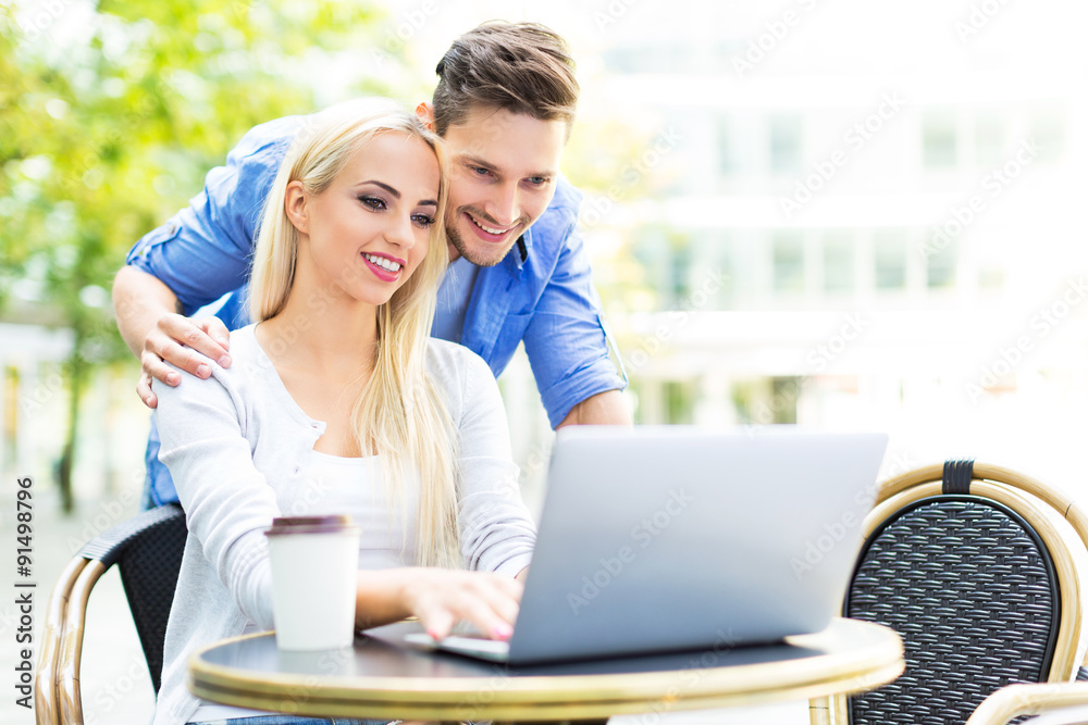 Couple using laptop at cafe Couple using laptop at cafe