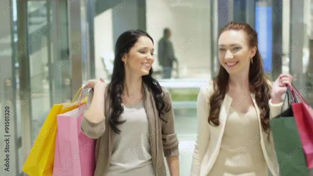 Two Happy and Smiling Girls are Getting Out of Elevator in Shopping Center Two Happy and Smiling Girls are Getting Out of Elevator in Shopping Center