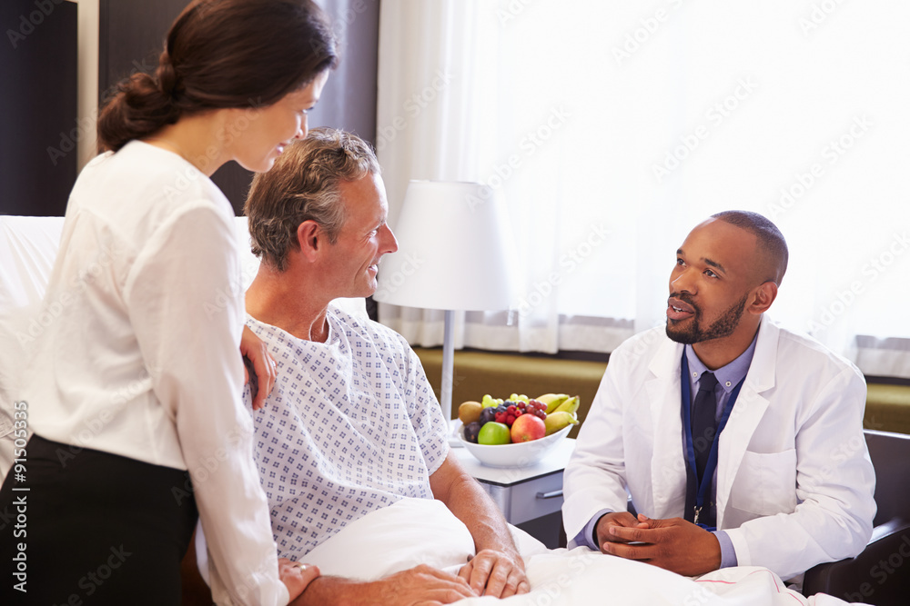 Obraz premium Doctor Talking To Male Patient And Wife In Hospital Bed