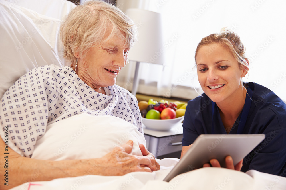 Nurse Talking To Senior Female Patient In Hospital Bed Nurse Talking To Senior Female Patient In Hospital Bed