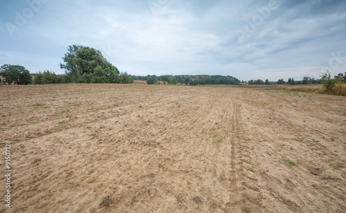 Beautiful plowed field under cloudy sky.