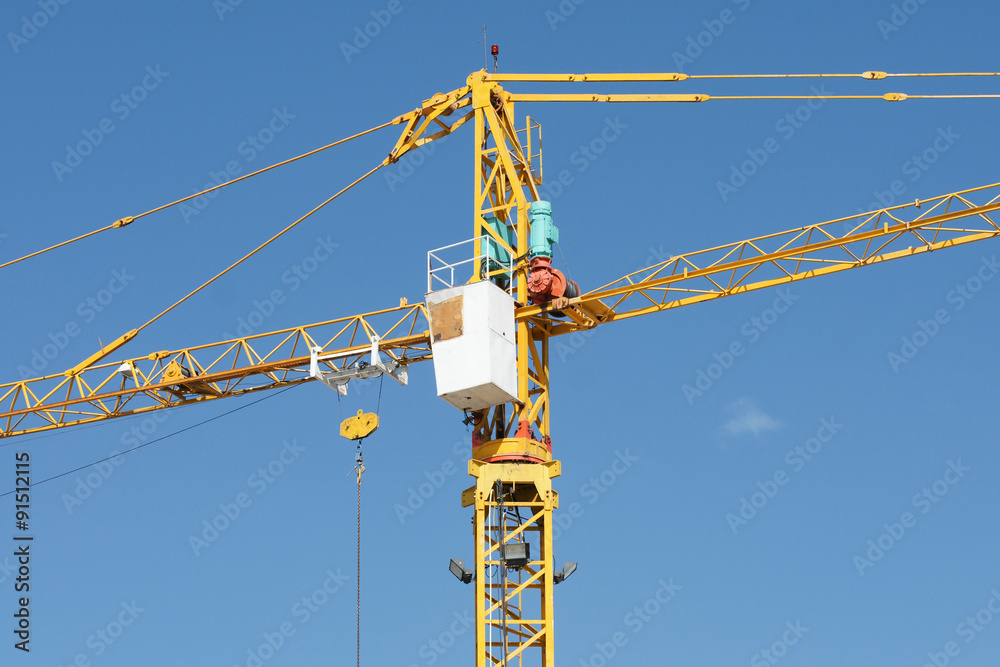 Yellow Industrial crane and blue sky on construction site or seaport Yellow Industrial crane and blue sky on construction site or seaport