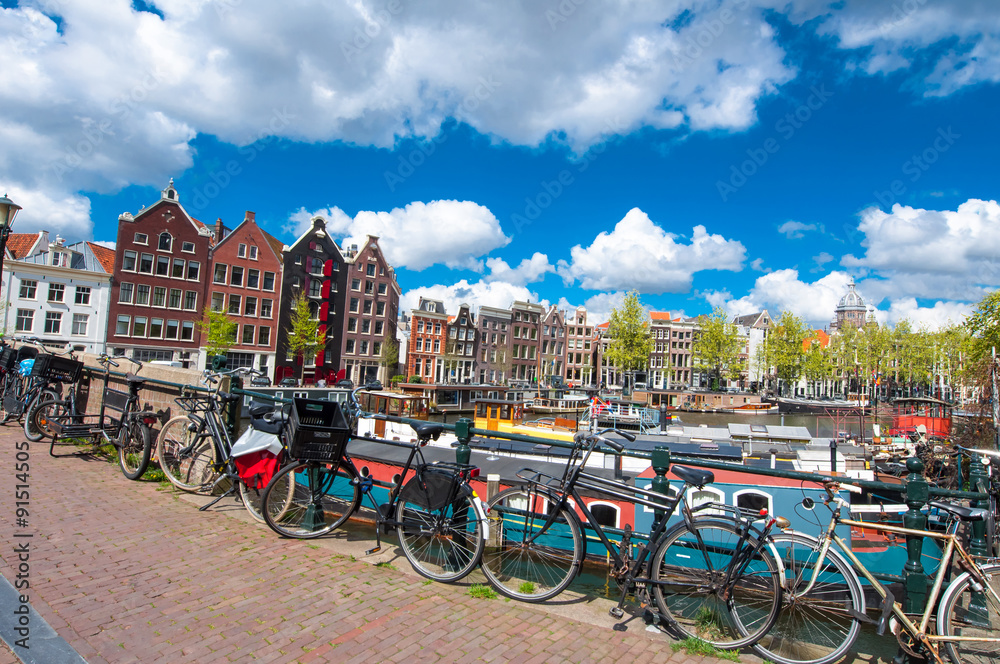 Amsterdam, the Netherlands-April 27: Traditional Amsterdam cityscape with medival houses, bikes on the bridge on April 27,2015. Amsterdam is the most populous city of the Kingdom of the Netherlands.