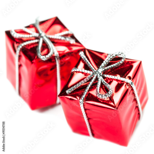 Red gift box with silver ribbon and bow isolated on white macro