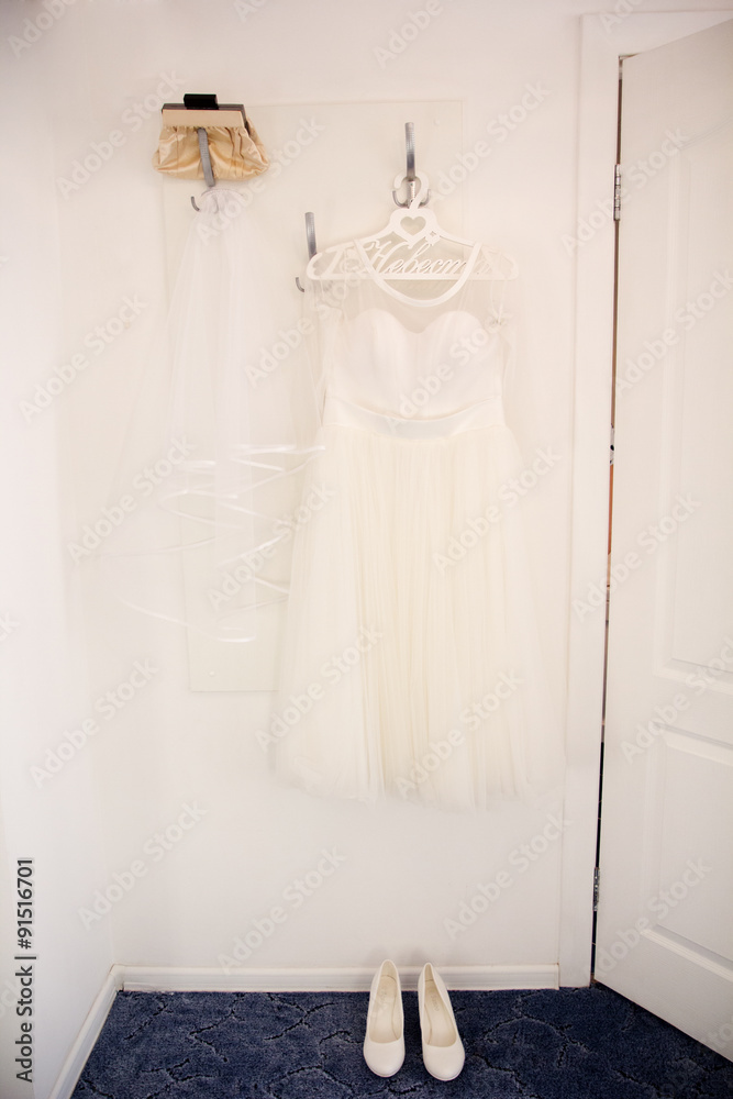 Bride dress and shoes is hanging on the hanger Bride dress and shoes is hanging on the hanger