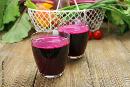 Glasses of beet juice with vegetables on table close up
