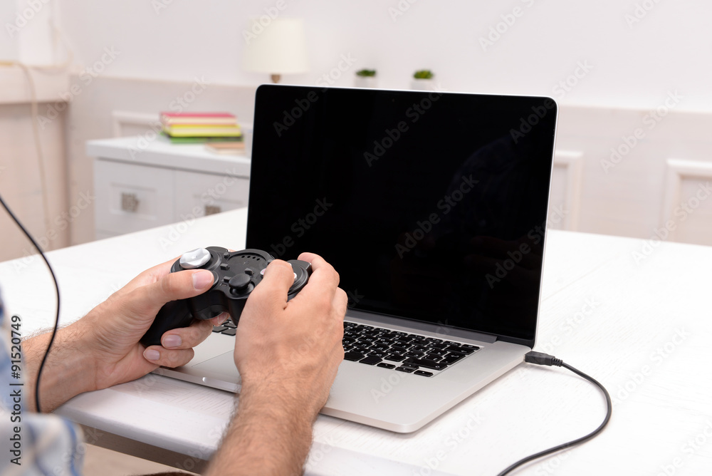Fototapeta premium Young man playing computer games at home