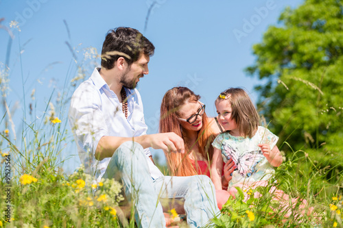 Family playing with wildflowers on meadow