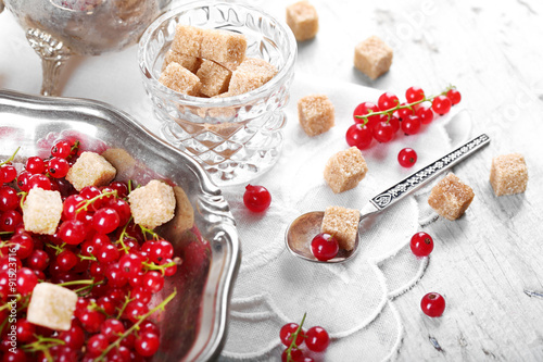 Fresh red currants with sugar on table close up