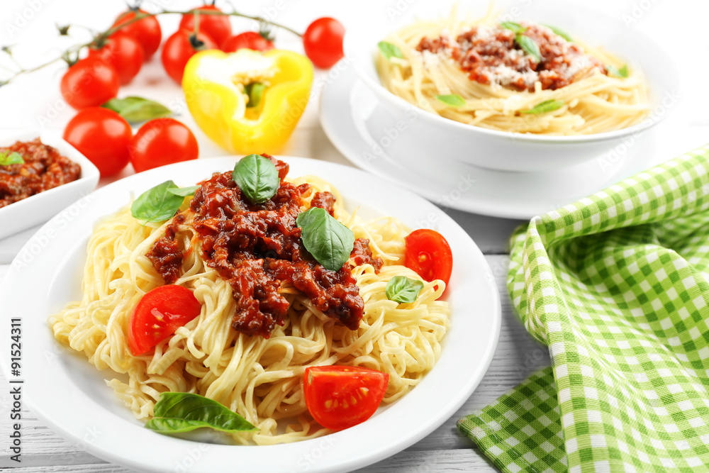 Spaghetti Bolognese on white plate, on color wooden background Spaghetti Bolognese on white plate, on color wooden background