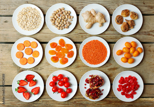 Wallpaper Mural Different products on saucers on wooden table, top view Torontodigital.ca