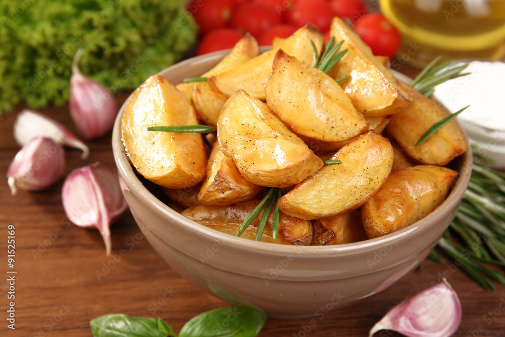 Baked potato wedges on wooden table, closeup Baked potato wedges on wooden table, closeup