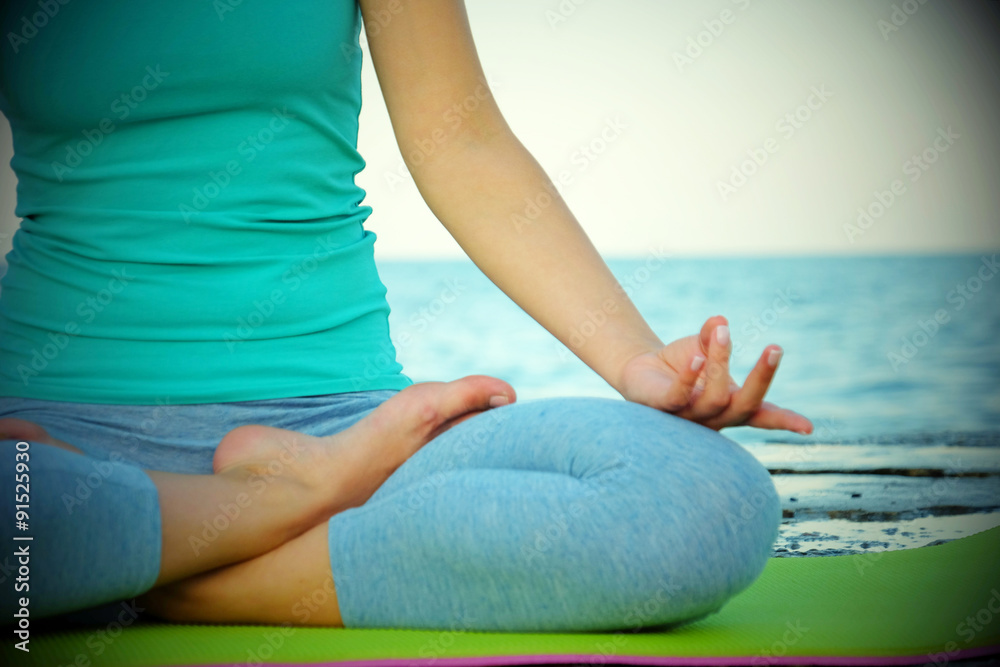 Young woman practicing yoga at seashore Young woman practicing yoga at seashore