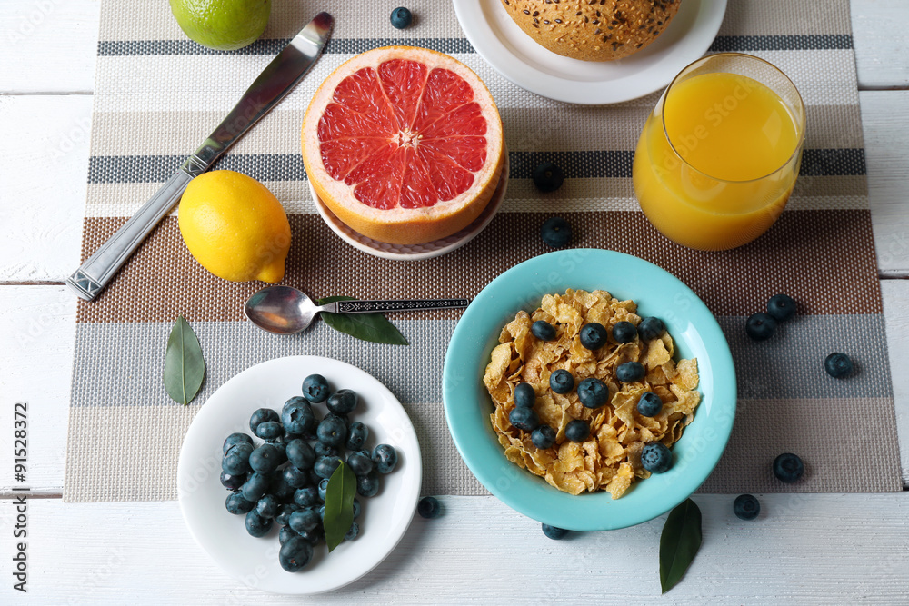 Tasty cornflakes with fruits and berries on table close up