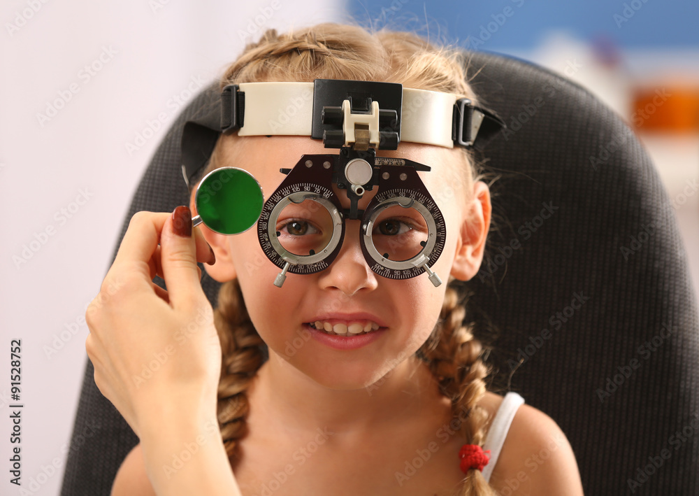 Young girl undergoing eye test with Spectacles on blurred background Young girl undergoing eye test with Spectacles on blurred background