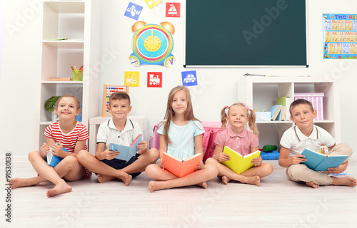 Row of children reading on ...