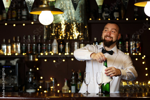 Wall Mural Portrait of handsome bartender with champagne bottle