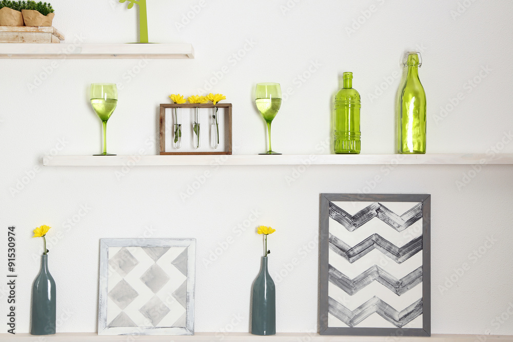 Different home objects and decoration on shelves on white wall background Different home objects and decoration on shelves on white wall background