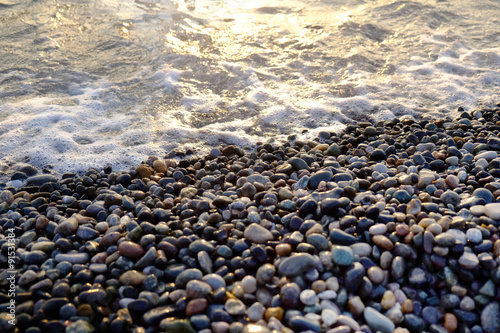Dark wet pebbles beach with sea waves