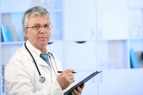 Doctor with digital tablet at his workplace