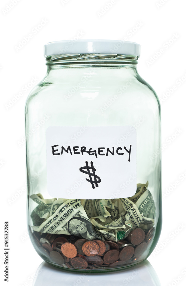 Glass jar with with a white emergency label and some money in it Glass jar with with a white emergency label and some money in it