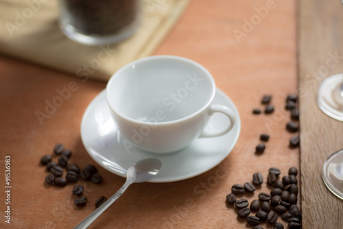 blurred coffee cup with bean on wood table in coffee shop