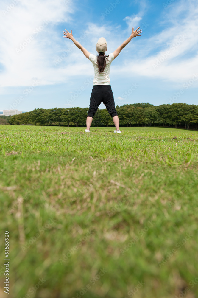 青空に向かって手を広げている女性の後ろ姿 青空に向かって手を広げている女性の後ろ姿