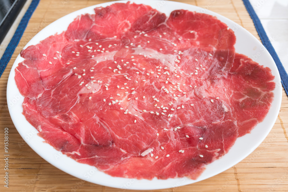 Slide raw beef on a dish on the table