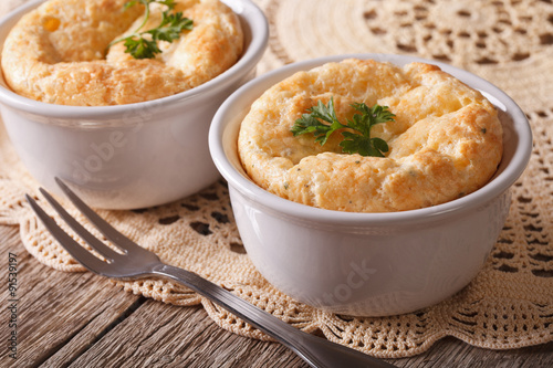 French baked cheese souffle in white rameken close-up. horizontal
 photo