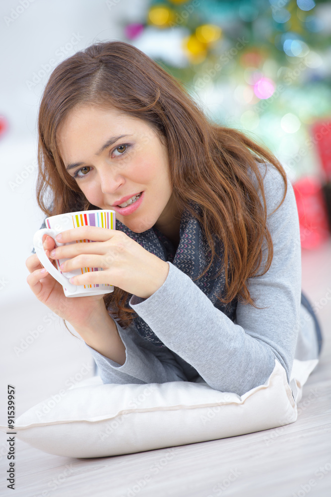 Woman laying on the floor with a cup of coffee Woman laying on the floor with a cup of coffee
