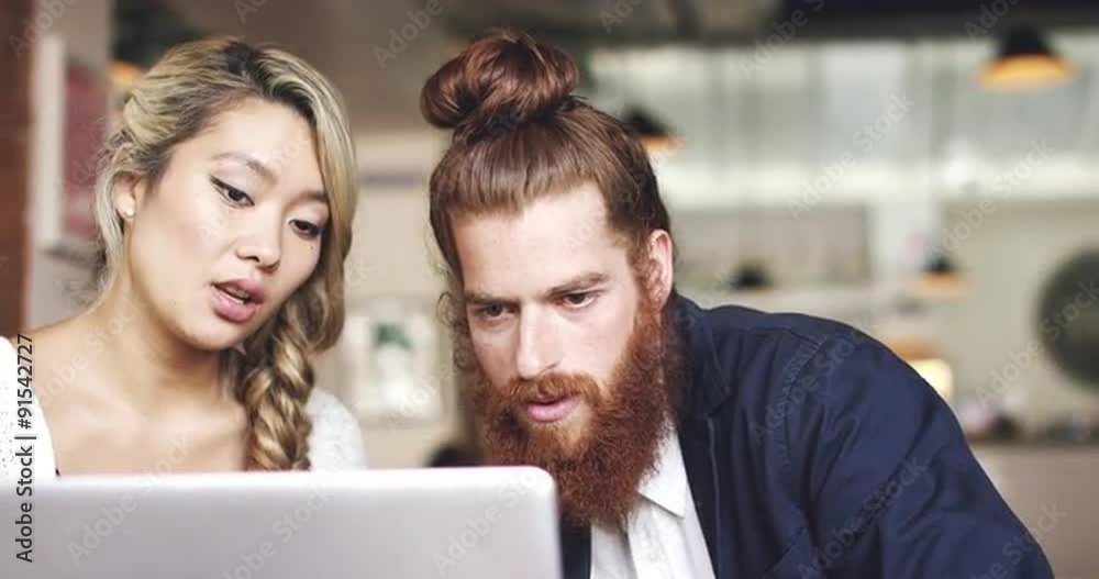 Young couple using digital tablet computer in cafe