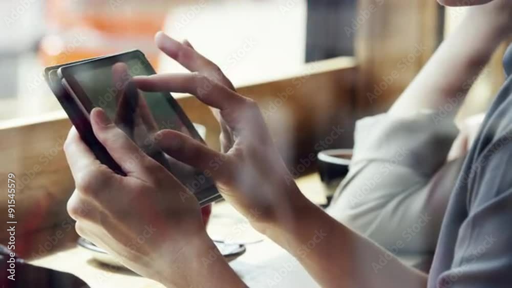 Closeup woman hands using ipad touchscreen tablet display in cafe