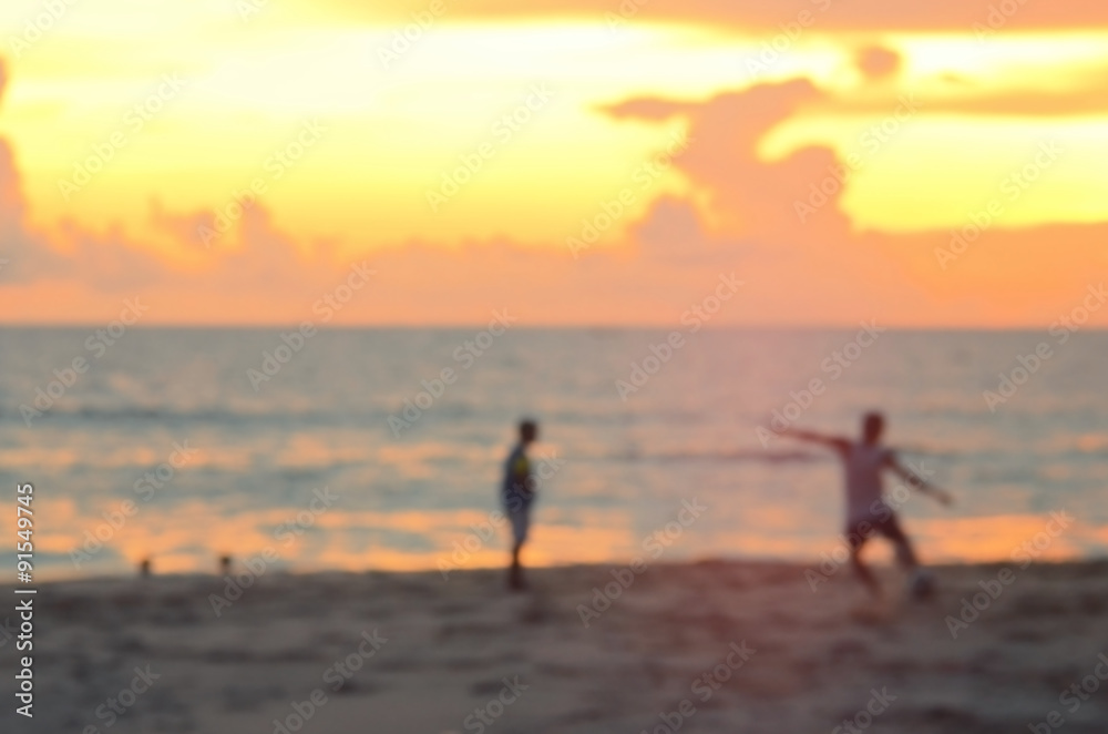 Blur boys playing football on beach abstract background.