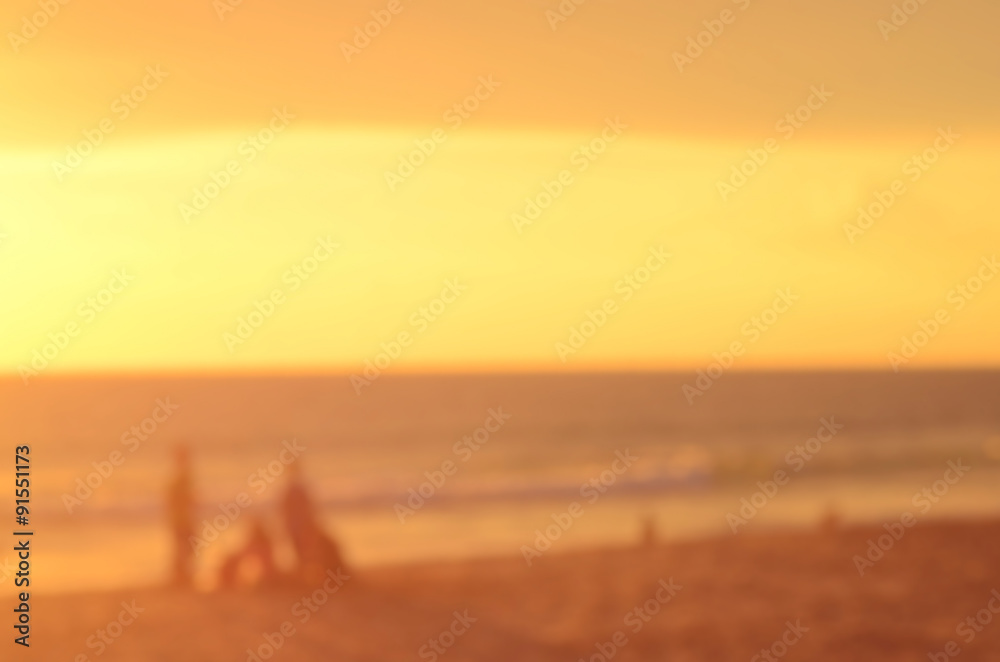 Blur people on sunset beach abstract background.