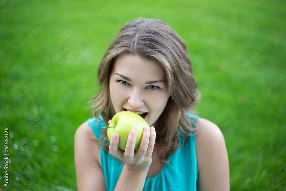 portrait of young beautiful woman biting apple in summer park portrait of young beautiful woman biting apple in summer park