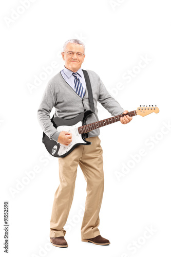 Confident senior playing on an electric guitar