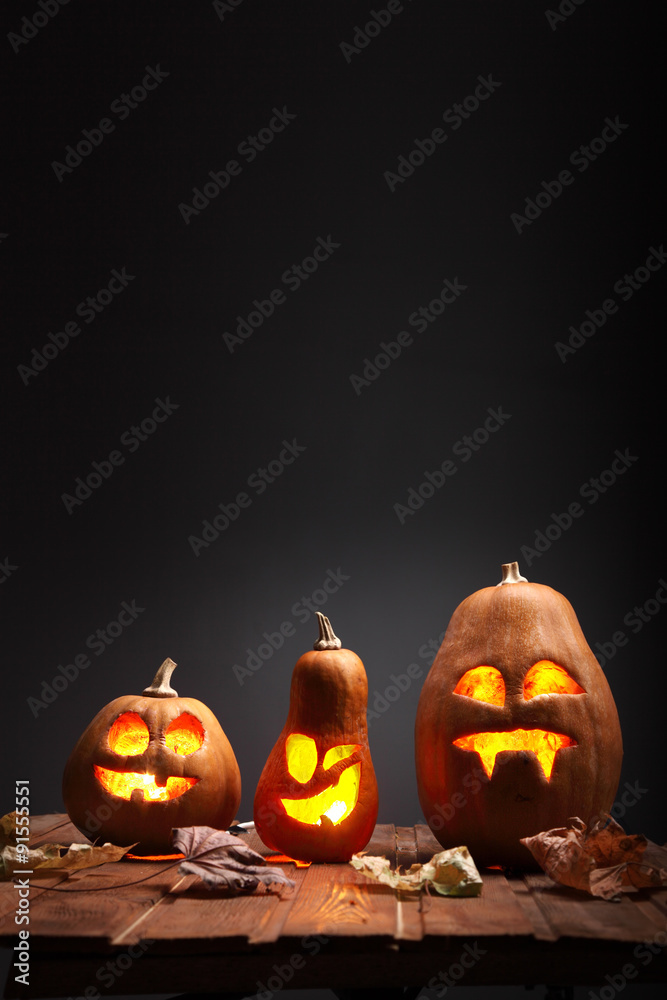 Fototapeta premium Jack o lanterns Halloween pumpkin face on wooden background