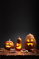 Jack o lanterns Halloween pumpkin face on wooden background