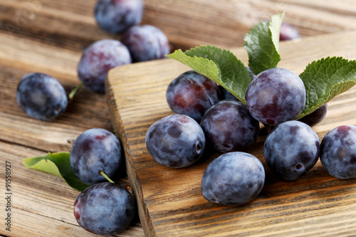 Fresh plums on brown wooden background