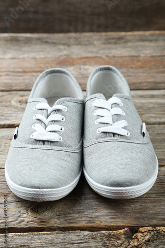 Pair of grey shoes on wooden background