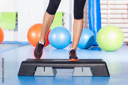 Close up of feet in step equipment at gym.