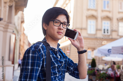 Asian man with mobile smartphone. Outdoor photo.