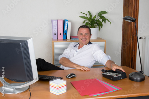 Manager man at his desk at work photo